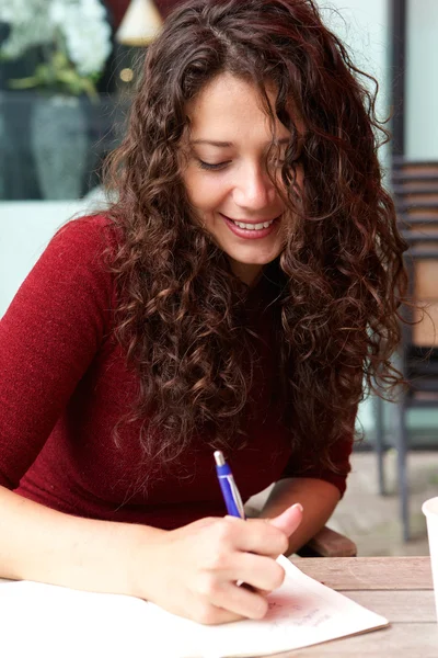 Vrouw aan het café en het schrijven van notities — Stockfoto