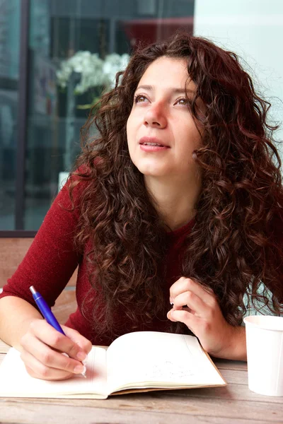 Vrouw schrijven dagboek in café — Stockfoto