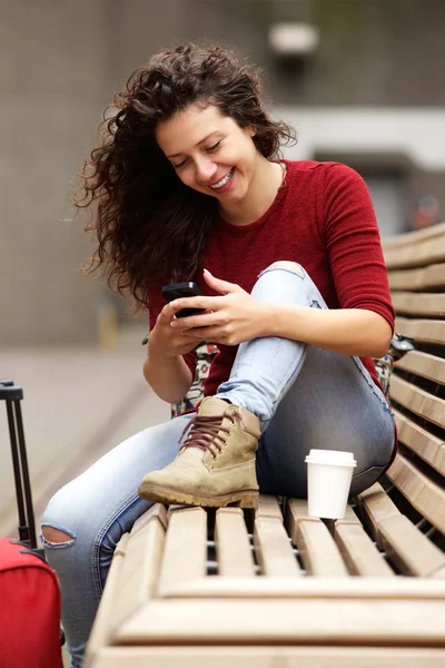 Mujer sentada en el banco usando el teléfono — Foto de Stock