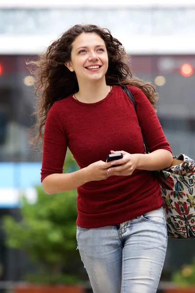 Kvinnan promenader utomhus med telefon — Stockfoto