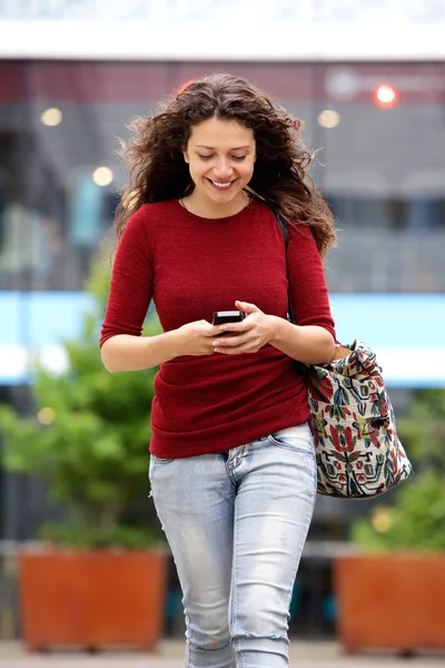 Vrouw lopen met mobiele telefoon — Stockfoto
