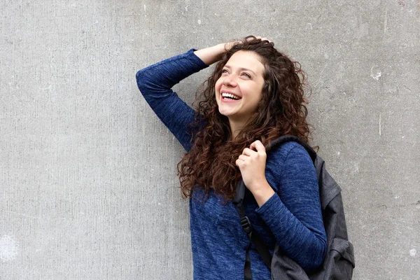 Vrouw met rugzak tegen grijze muur — Stockfoto