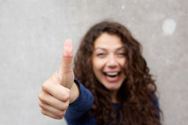 Cheerful young woman giving thumb up 