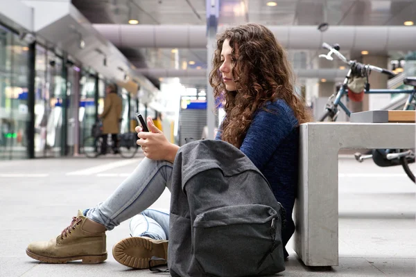 Женщина сидит на улице с помощью телефона — стоковое фото