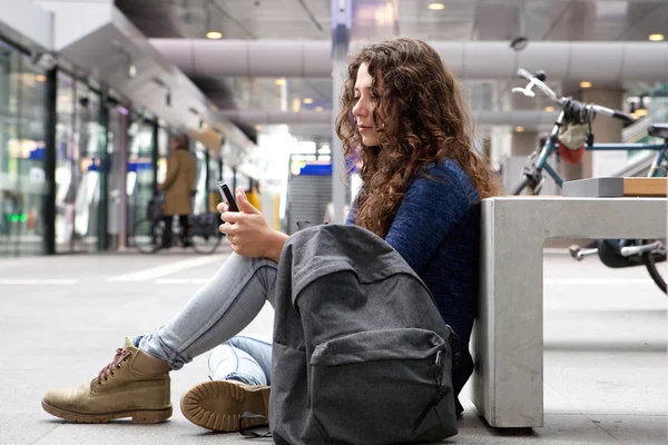 Vrouw zitten buiten met behulp van telefoon — Stockfoto