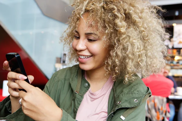 Leende ung kvinna med mobiltelefon — Stockfoto