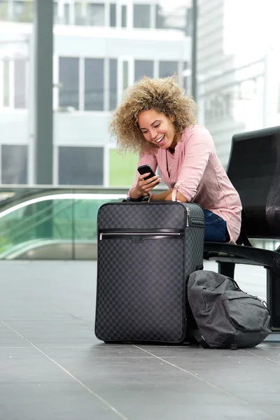 Femme attendant avec valise et téléphone — Photo