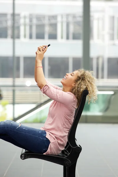 Jonge vrouw zit en het nemen van de selfie — Stockfoto