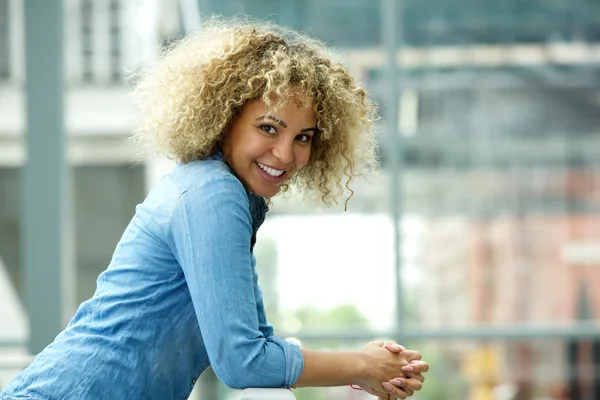 Jovem mulher sorrindo e inclinada — Fotografia de Stock