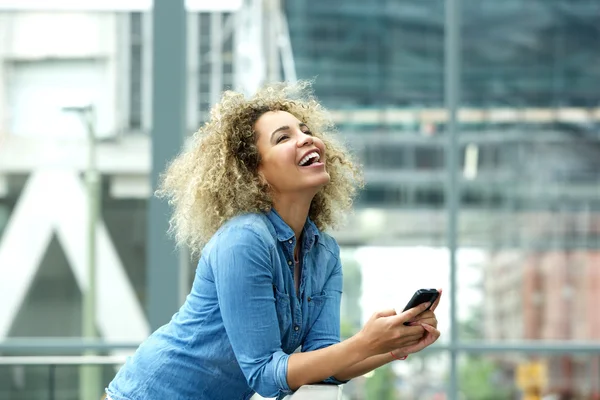 Frau lacht mit Smartphone — Stockfoto