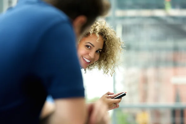 Woman with mobile phone looking at man — Stock Photo, Image