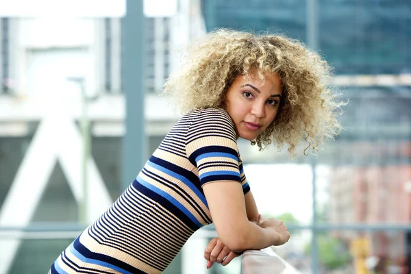 Serious young woman leaning on railing — Stock Photo, Image