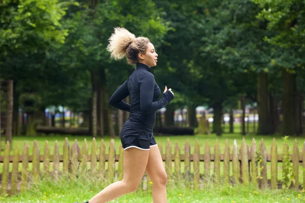 Sportovní mladá žena běží mimo — Stock fotografie