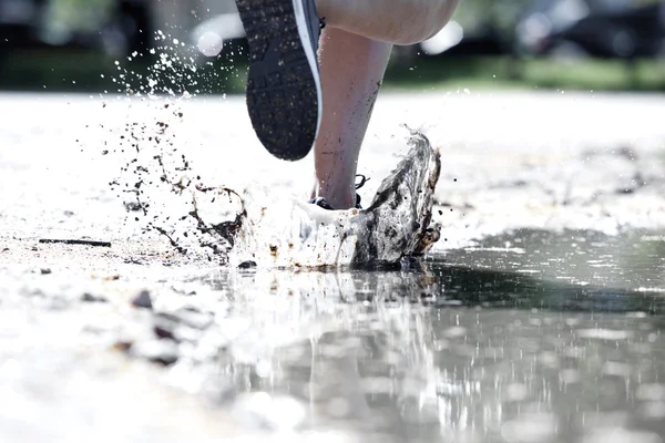 Runner splash in puddle — Stock Photo, Image