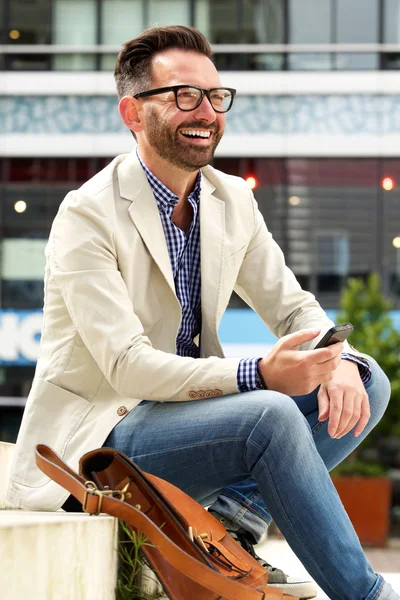 Hombre mayor sonriente con teléfono celular — Foto de Stock