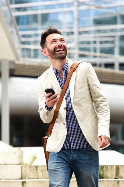 Olgun adam açık havada hareket eden telefon ile gülümseyen — Stok fotoğraf