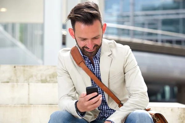 Homem feliz olhando para seu telefone celular — Fotografia de Stock
