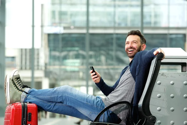 Gelukkig volwassen man zit bij het station — Stockfoto