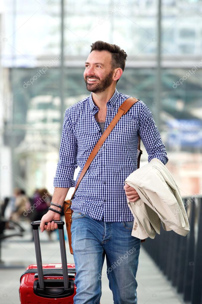 Smiling mature man traveling with suitcase