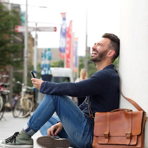 Avslappnad mogen man leende med mobiltelefon — Stockfoto