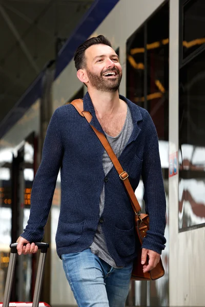 Happy mature man on train station platform with bag — Stock Photo, Image