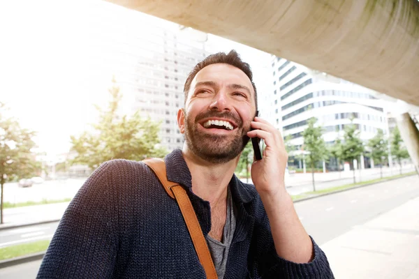 Красива зріла людина посміхається і розмовляє на мобільному телефоні — стокове фото