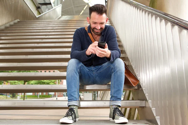 Sorridente ragazzo di mezza età utilizzando il telefono cellulare — Foto Stock