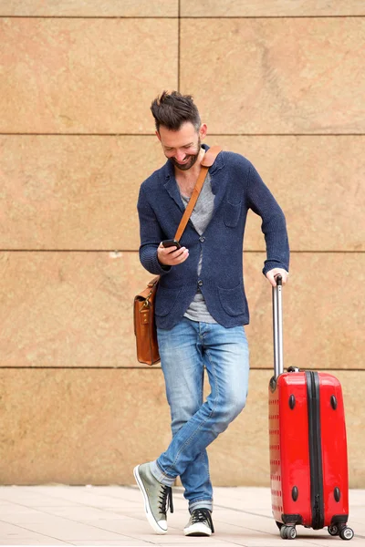 Hombre con maleta y teléfono móvil — Foto de Stock