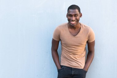 Yatay portre mutlu genç Afrikalı Amerikalı adam gri arka planda gülümsüyor