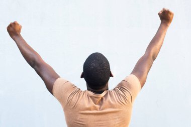 Arka portre genç siyah adam kollarını kaldırdı ve yumruk pompaladı.