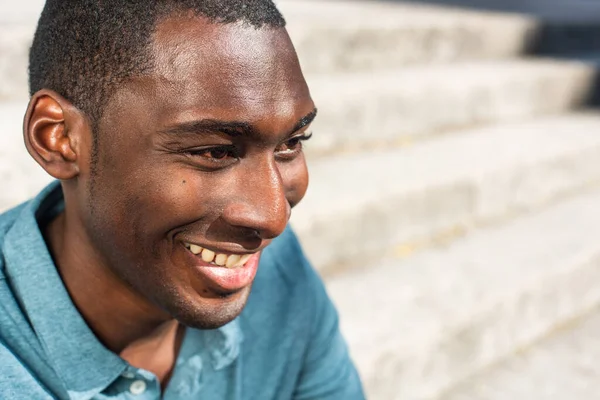 Close up horizontal side portrait young African American man smiling and looking away