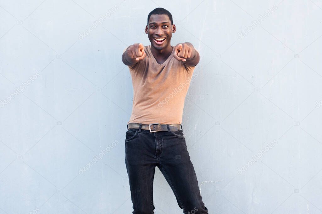 Portrait cheerful young black man pointing fingers at viewer