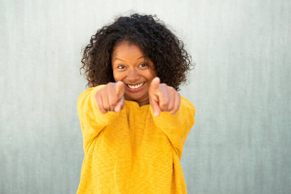 Портрет улыбающейся молодой женщины, указывающей на тебя пальцем