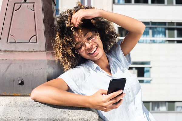 Portret Szczęśliwy Młoda Afroamerykanka Patrzy Telefon Zewnątrz — Zdjęcie stockowe