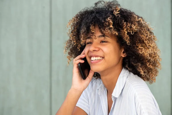 特写年轻的非洲裔美国女人一边微笑一边用手机交谈 — 图库照片