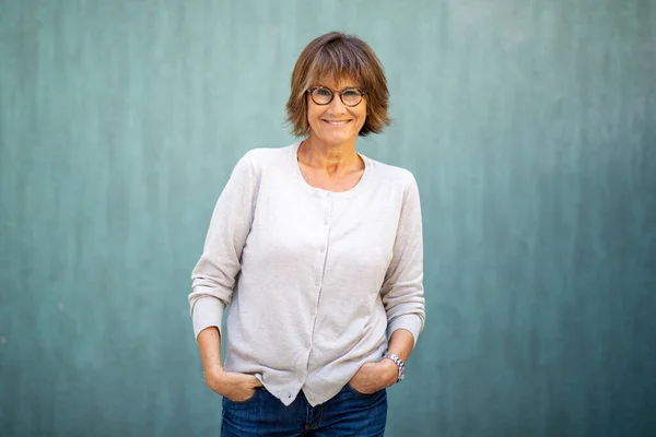 Porträt Ältere Frau Lächelt Mit Brille Vor Grünem Hintergrund — Stockfoto