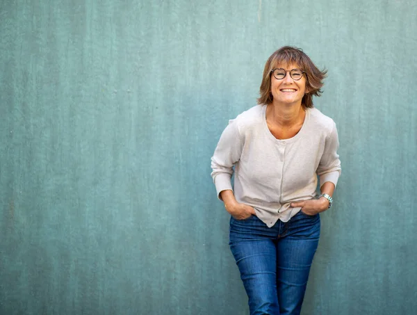Porträt Ältere Frau Lehnt Grüne Wand Und Lächelt — Stockfoto