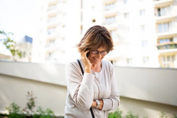 Porträtt Glad Äldre Kvinna Skrattar Och Talar Med Mobiltelefon Utanför — Stockfoto