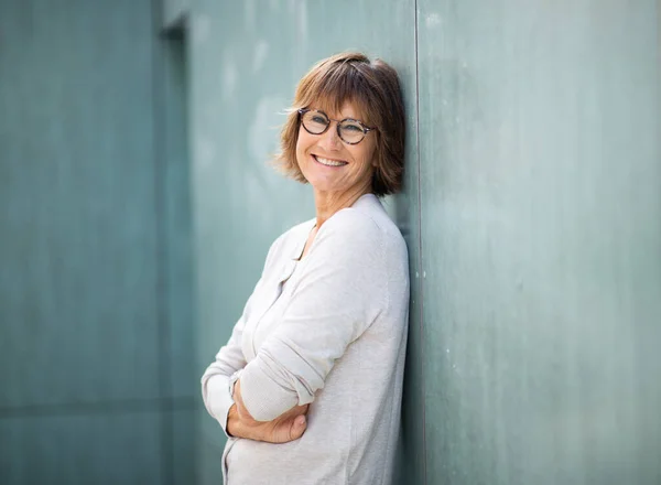 Zijportret Lachende Oudere Vrouw Leunend Tegen Muur Met Gekruiste Armen — Stockfoto