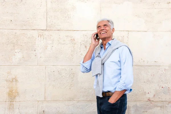 Boczny Portret Uśmiechniętego Mężczyzny Rozmawiającego Telefonem Przez Białą Ścianę — Zdjęcie stockowe