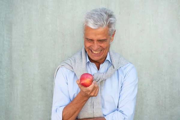 Portret Uśmiechniętego Starszego Mężczyzny Patrzącego Jabłko Dłoni — Zdjęcie stockowe
