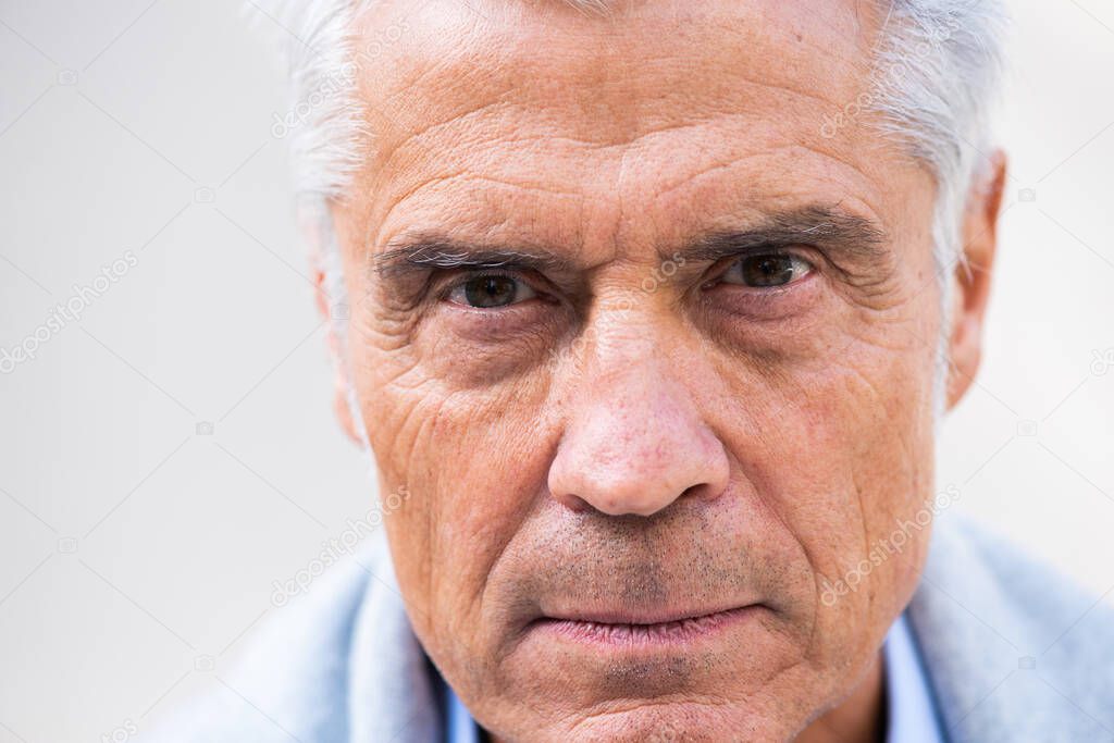 Close up portrait of older man head with eyes staring 