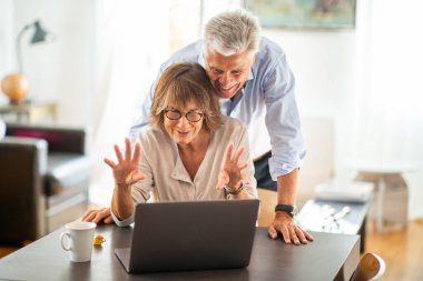 Video araması sırasında dizüstü bilgisayara bakan mutlu çift portresi 