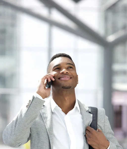 Młody człowiek african american uśmiechający się z telefonem komórkowym — Zdjęcie stockowe