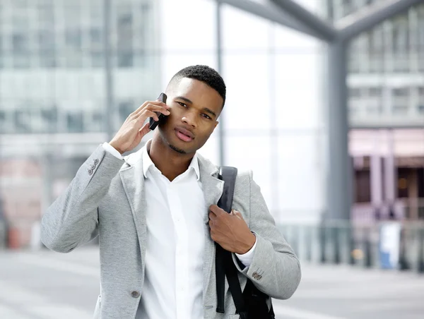 Cool unge mannen med väskan talar i mobiltelefon — Stockfoto
