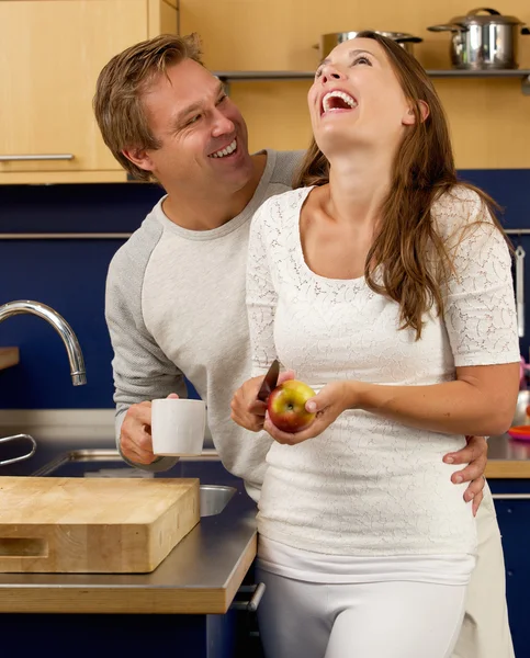 Pareja feliz riendo en la cocina —  Fotos de Stock