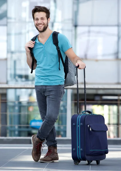 Jeune homme qui attend à l'aéroport avec valise et sac — Photo