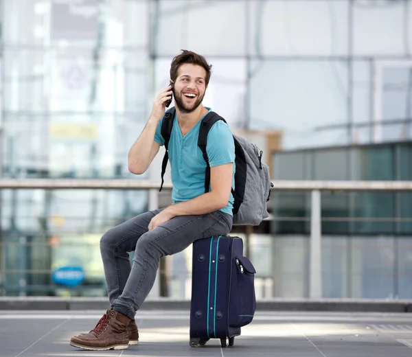 Jonge man die door mobiele telefoon op de luchthaven — Stockfoto