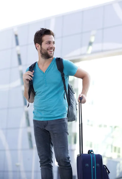 Young man waiting outside with bags — Stock Photo, Image