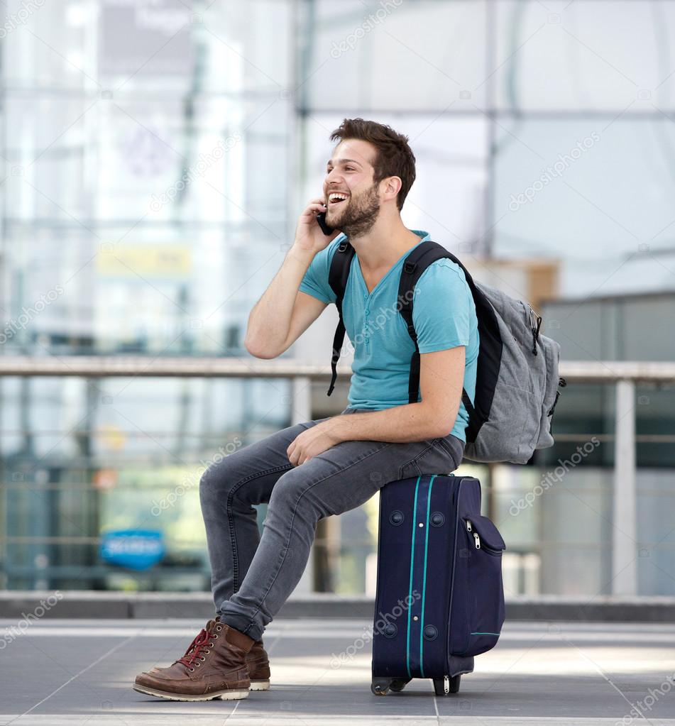 Man relaxing at airport and talking on mobile phone